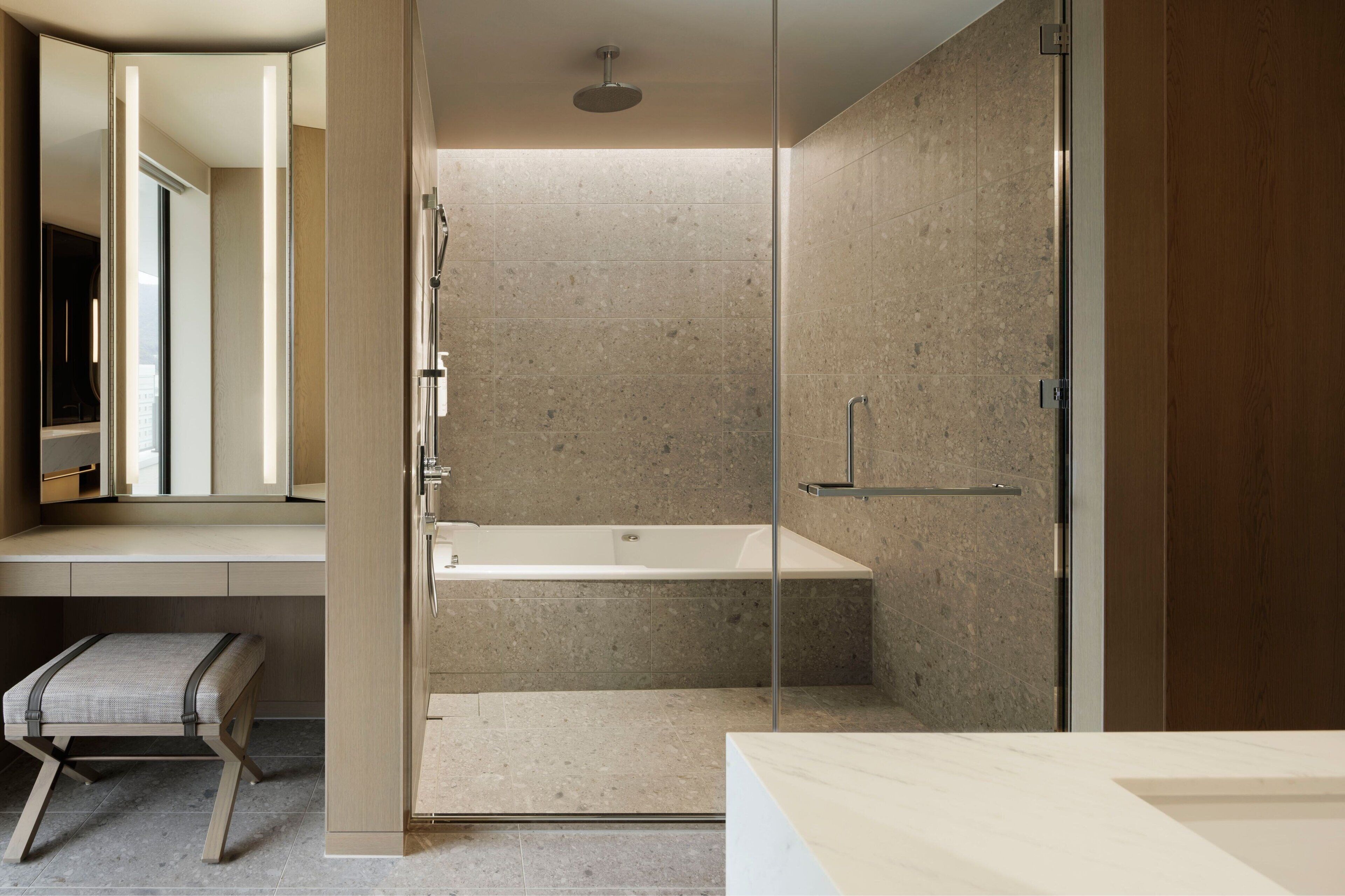 A modern bathroom with a glass-enclosed shower, a built-in bathtub, and a vanity with a mirror.