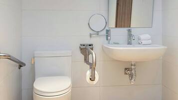 Un baño con inodoro, lavabo y espejo.