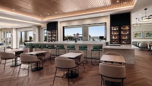 A modern bar area with wooden ceiling, bar stools, and a large window overlooking the city. - SpringHill Suites by Marriott Chula Vista Eastlake (Chula Vista)