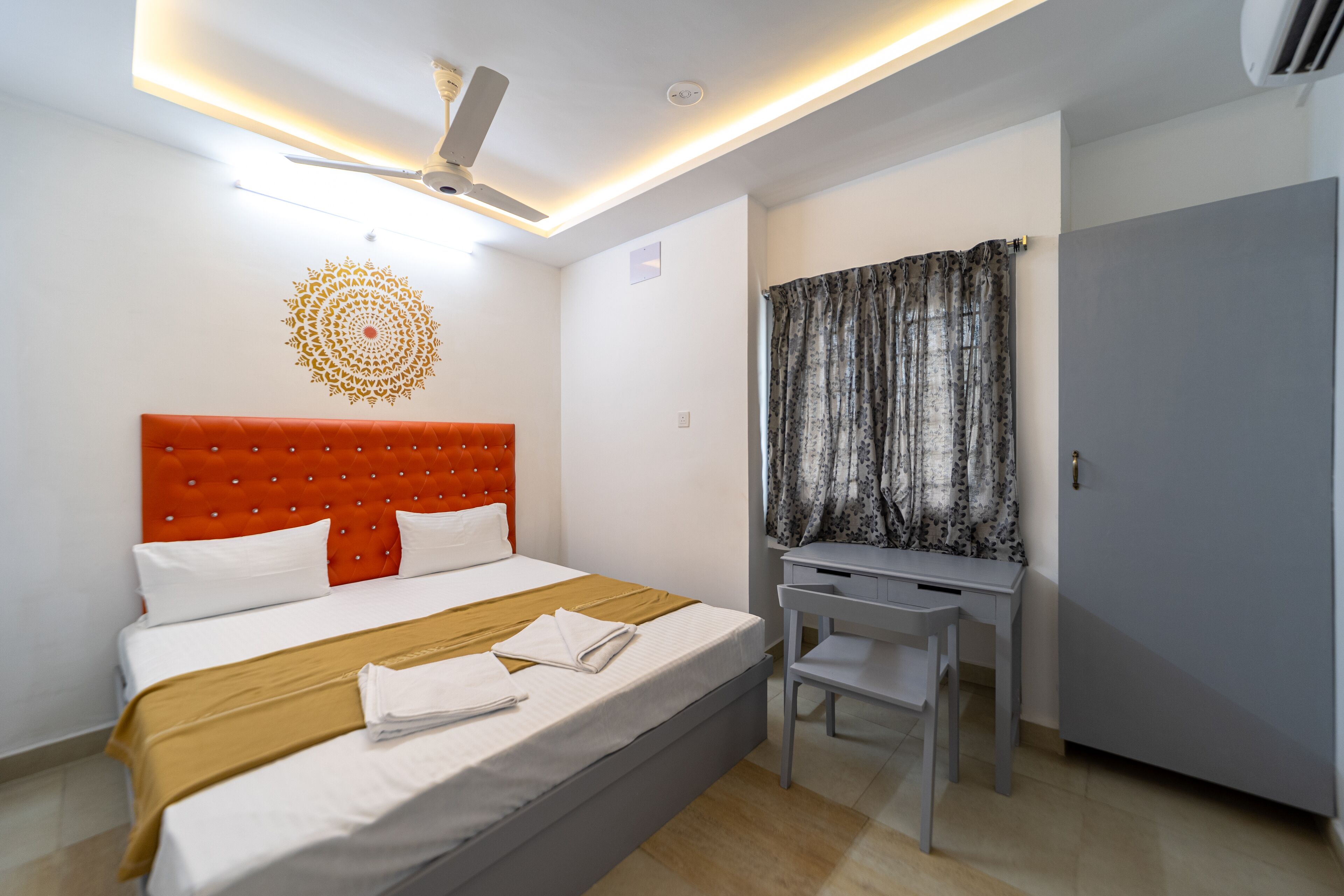 A hotel room with a bed, a desk, and a wardrobe.