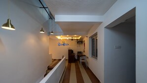 A hallway with a striped floor, pendant lighting, a desk, and a sign that reads "Bonne Chance".
