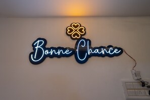 A neon sign with the text "Bonne Chance" and a clover symbol above it. - Bonne Chance Heritage Residence (Puducherry)