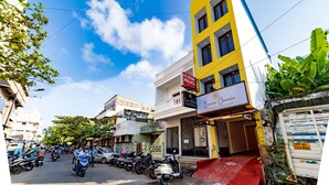 A multi-story building with a yellow facade, a sign for 'Bonnelyance Heritage Residence', and several parked scooters.