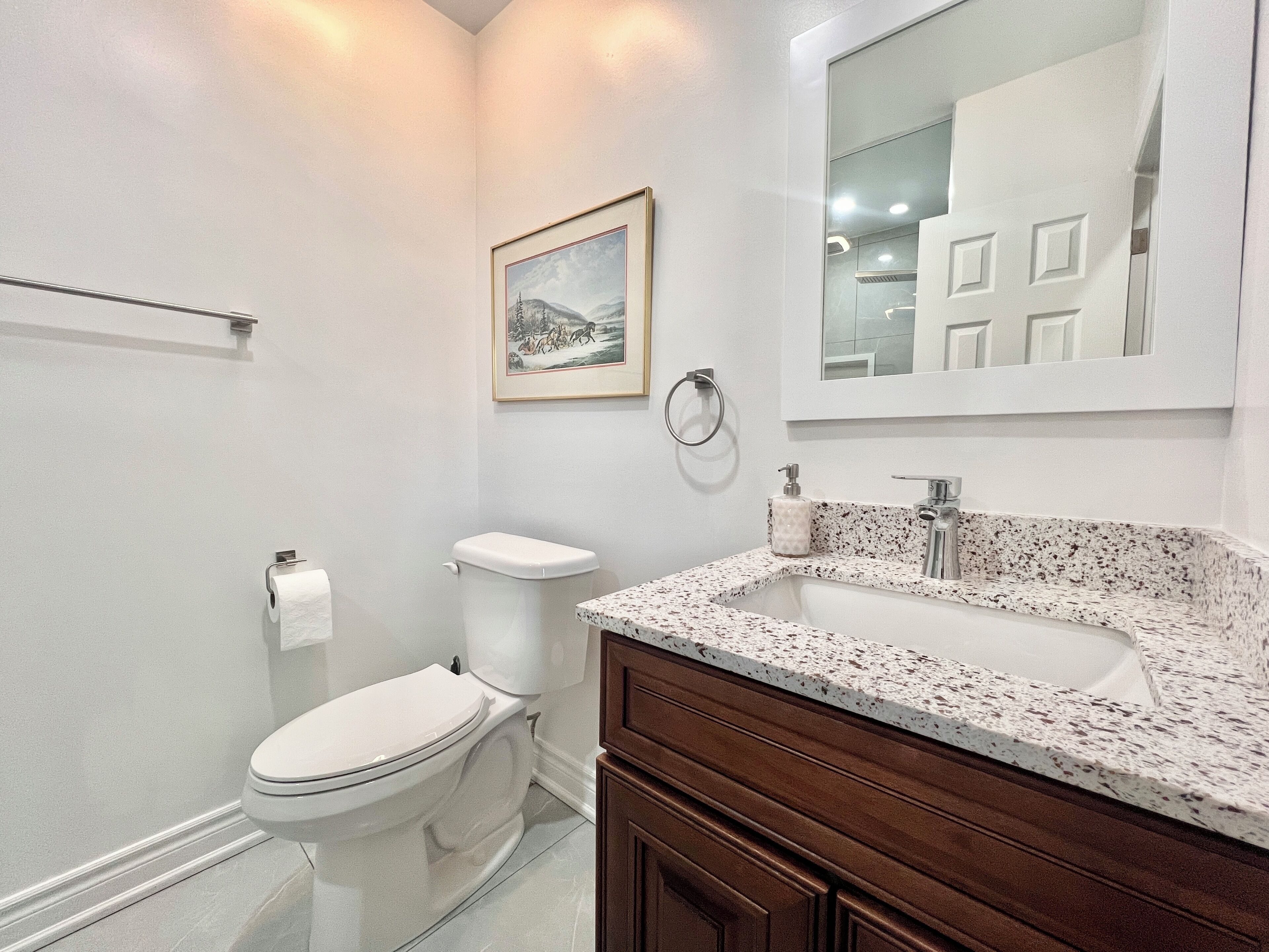 Un baño moderno con inodoro, lavamanos y tocador.