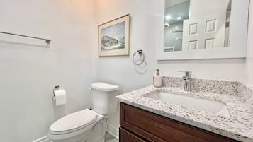 Un baño moderno con inodoro, lavamanos y tocador.