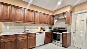 A kitchen with wooden cabinets, a stainless steel range, a microwave, and a dishwasher.
