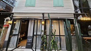 Un edificio con letrero de cerrado, letrero de cafetería y una ventana con cortinas.