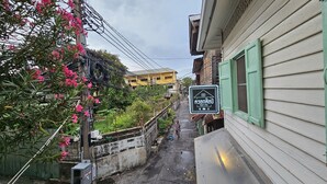 Un callejón estrecho con un edificio a la derecha que muestra un letrero de cafetería y tienda.