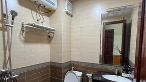 A bathroom with a toilet, sink, shower, and a mirror. - Thu Do Vang Hotel Ha Dong By Bay Luxury (Hanoi)