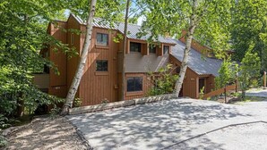 A wooden cabin with a sloped roof, surrounded by trees. - The Mountain Retreat - Loon Mtn - Pools - Views - Shuttle Service (Lincoln)