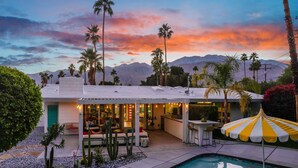 A modern house with a pool, outdoor seating, and palm trees. - Luxury Escapade w/ Pool, Hot Tub & Mountain Views (Palm Springs)
