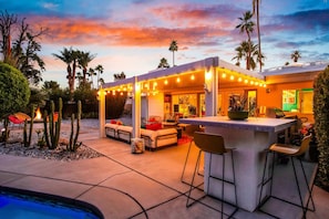 A patio area with outdoor seating, a bar, and a pool. - Luxury Escapade w/ Pool, Hot Tub & Mountain Views (Palm Springs)
