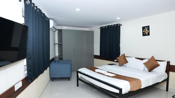 Une chambre d’hôtel moderne équipée d’un lit, d’une télévision, d’une armoire et d’un bureau.