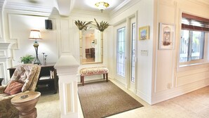 A well-lit hallway with a bench, a lamp, and framed pictures on the walls. - Riverwood Hutchinson Island (Stuart)