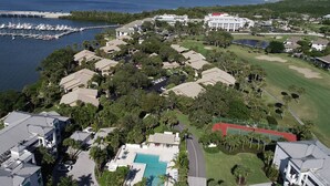 An aerial view of a coastal residential area with multiple houses, a marina, and a golf course. - Riverwood Hutchinson Island (Stuart)