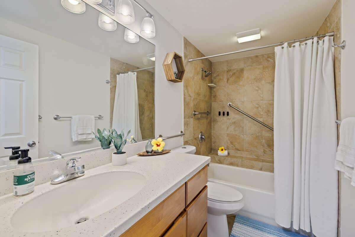 Une salle de bain moderne avec un grand lavabo, un miroir et une douche.