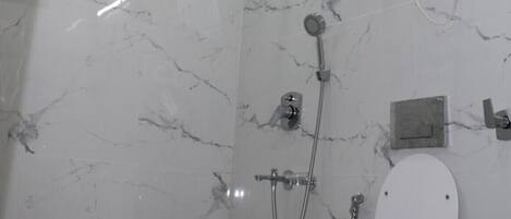 A modern bathroom with a shower, toilet, and a ceiling-mounted water heater.