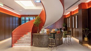 Ein modernes Interieur mit einer Wendeltreppe, einer Küchenzeile und Barhocker.