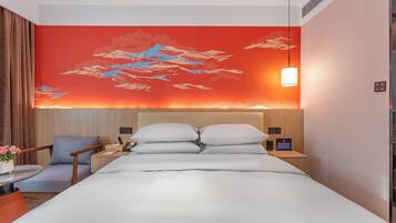 A hotel room with a bed, a nightstand, a chair, and a wall with a red design.