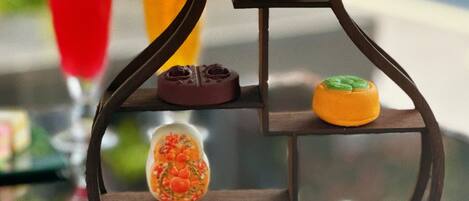 A dessert display with various sweets on a tiered stand.
