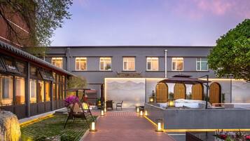 A courtyard with a wooden deck, outdoor seating, and a water feature.