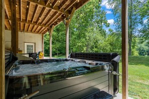 A hot tub under a wooden pergola with a view of a lush green landscape. - Riverfront, Hot Tub, Game Room, Camp Fire and More! (McVeytown)