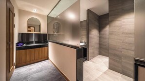 Een moderne hotelbadkamer met een wastafel, spiegel en een bordje met de tekst 'HOTEL NEW CASTLE'.