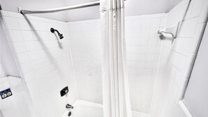 A small, white-tiled shower with a handheld showerhead and a curtain. - Imperial Motel (Mullins)