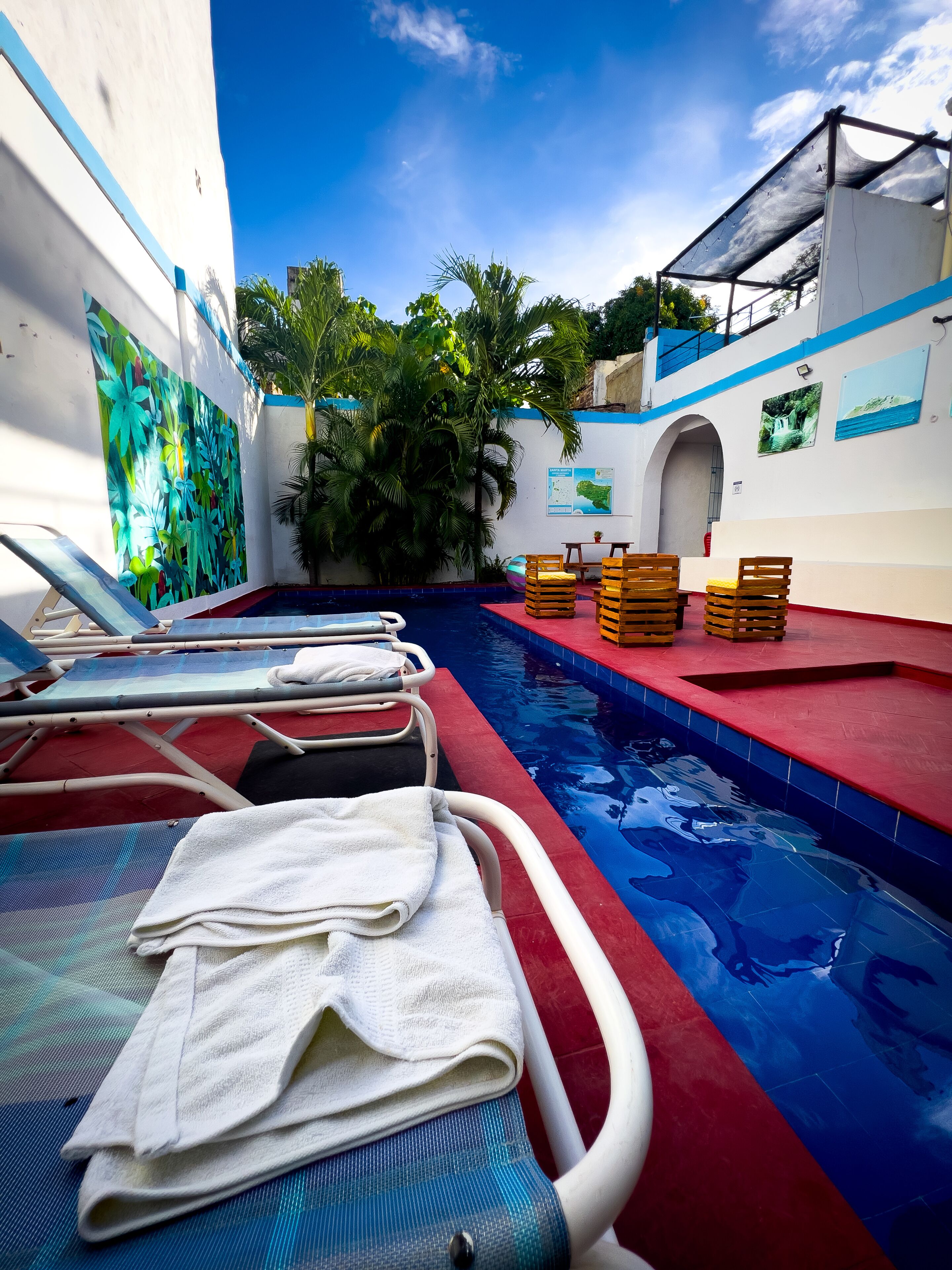 A pool area with lounge chairs, towels, and a small pool.