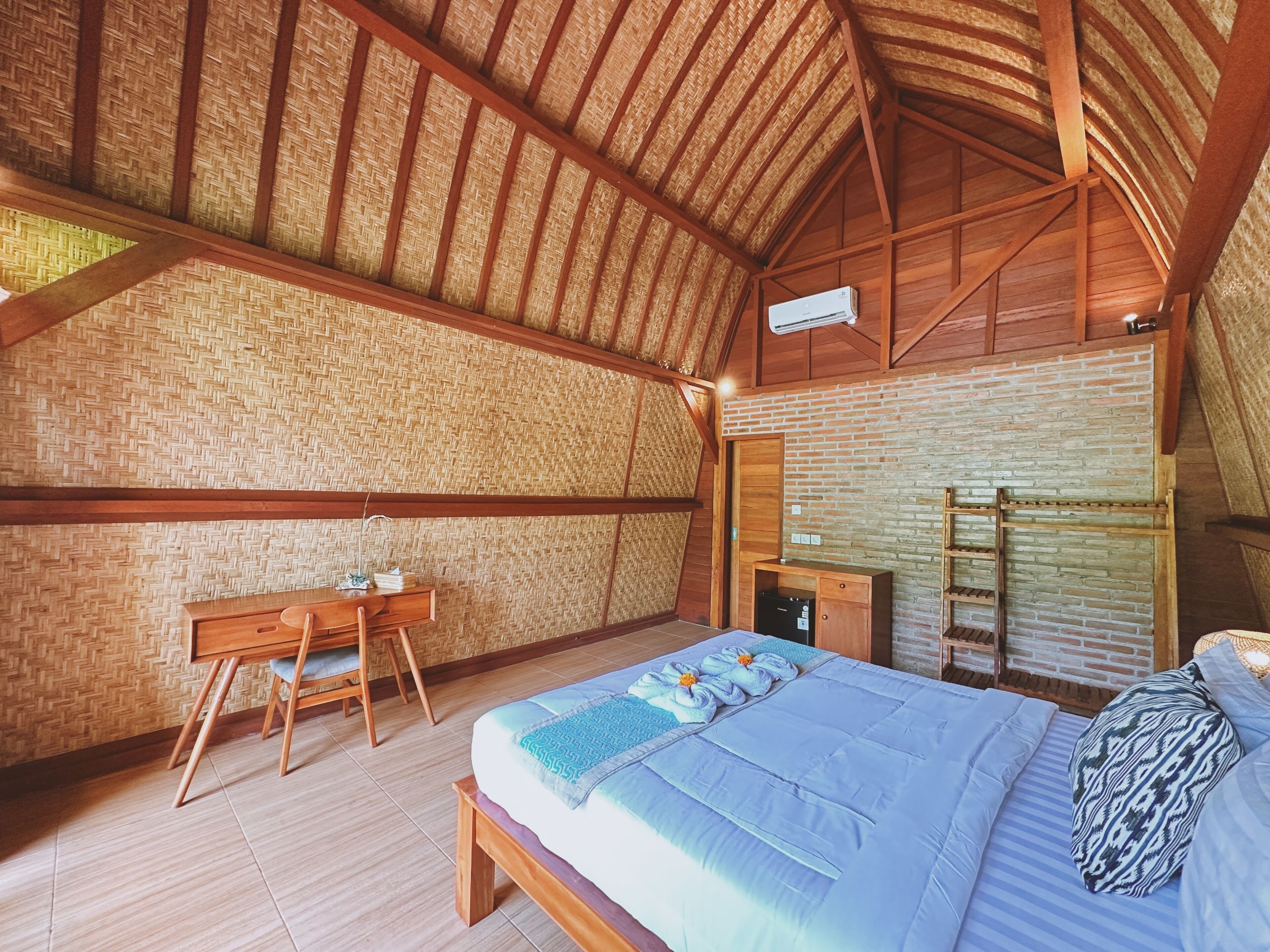 A bedroom with a bed, a desk, and a wardrobe.