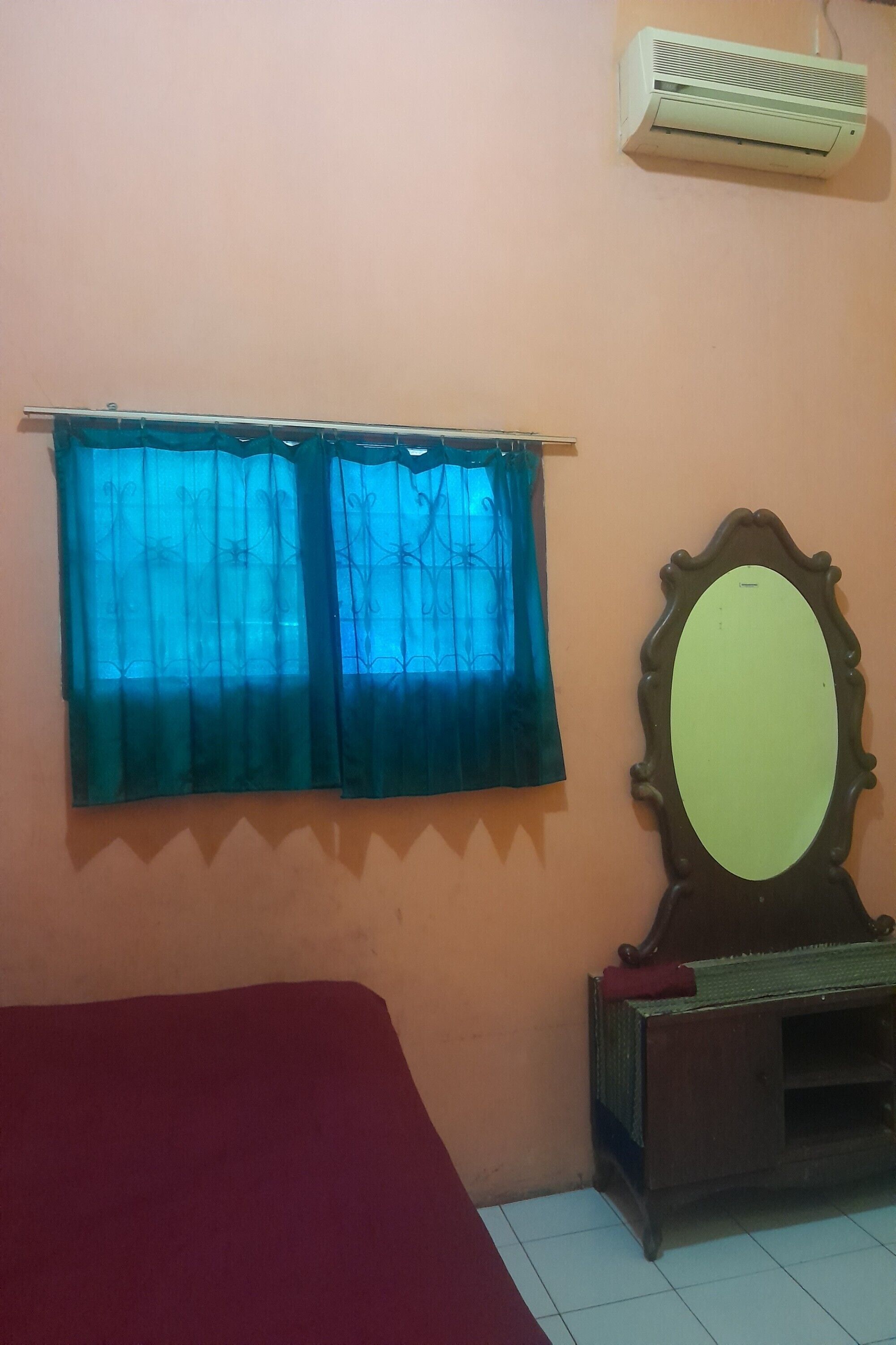 A room with a bed, a mirror, and an air conditioner.