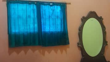 Una habitación con cama, espejo y aire acondicionado.