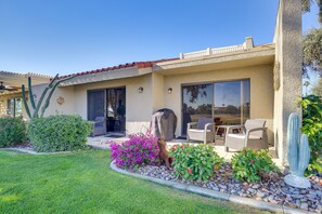 A house with a patio, outdoor furniture, and a cactus sculpture. - Palm Desert Condo w/ Patio & Golf Course Views! (Palm Desert)