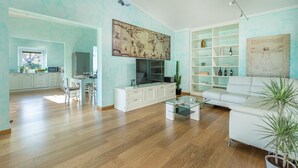 A spacious living area with a dining table, white sofa, and a large world map on the wall. - Villa Vivi 8 Emma Villas (Monte San Savino)