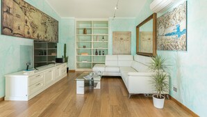A modern living room with a white sofa, a glass coffee table, and a large map on the wall. - Villa Vivi 8 Emma Villas (Monte San Savino)