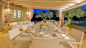 Un coin repas avec un mur en pierre, un canapé et une table mise pour le repas.
