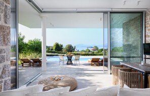 Ein moderner Außenbereich mit Pool, Liegestühlen und Esstisch.