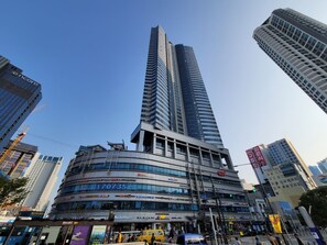 A modern building with multiple floors, featuring a prominent curved structure at the base. - W Residence Hotel Haeundae (Busan)