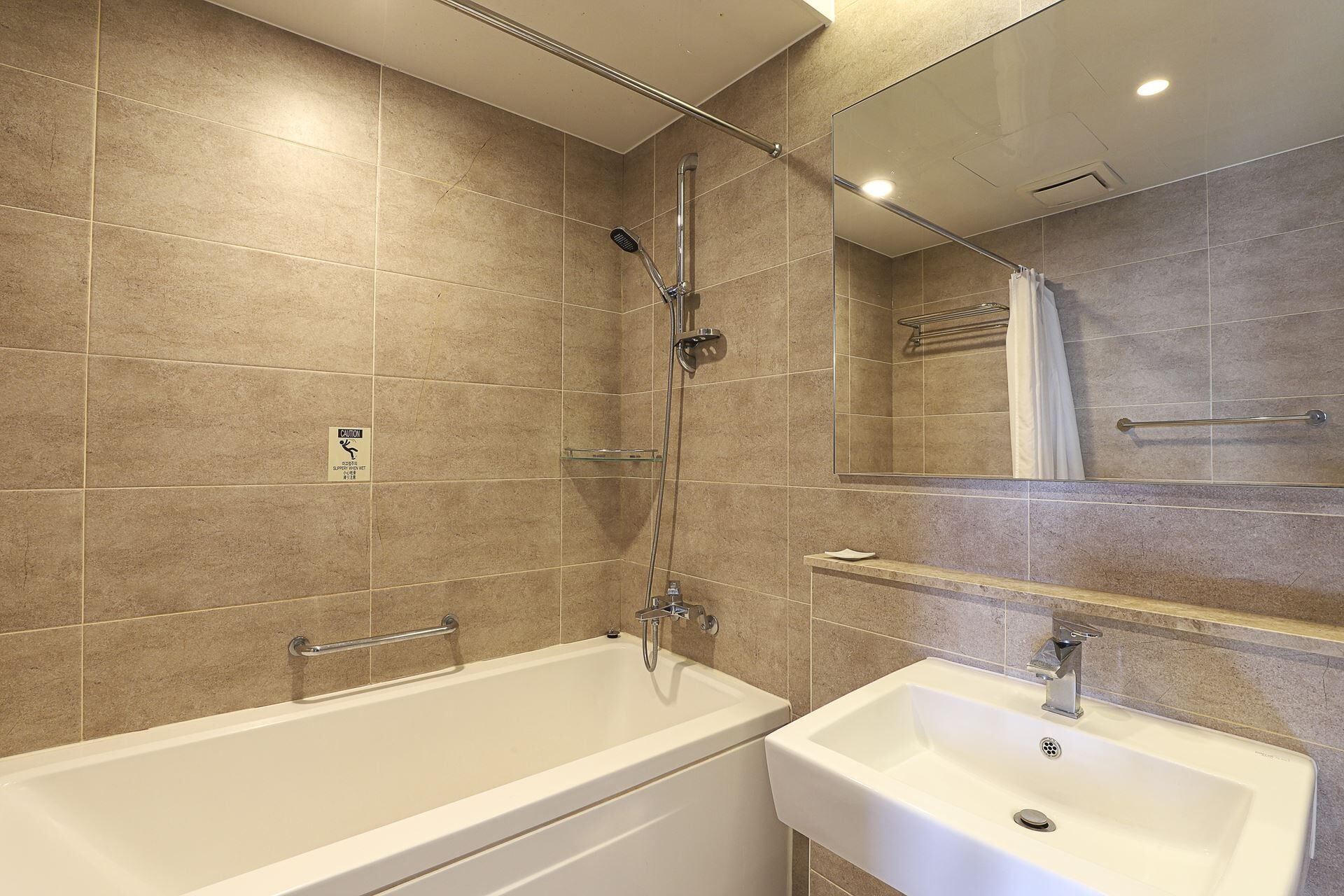 A modern bathroom with a bathtub, a sink, and a shower.