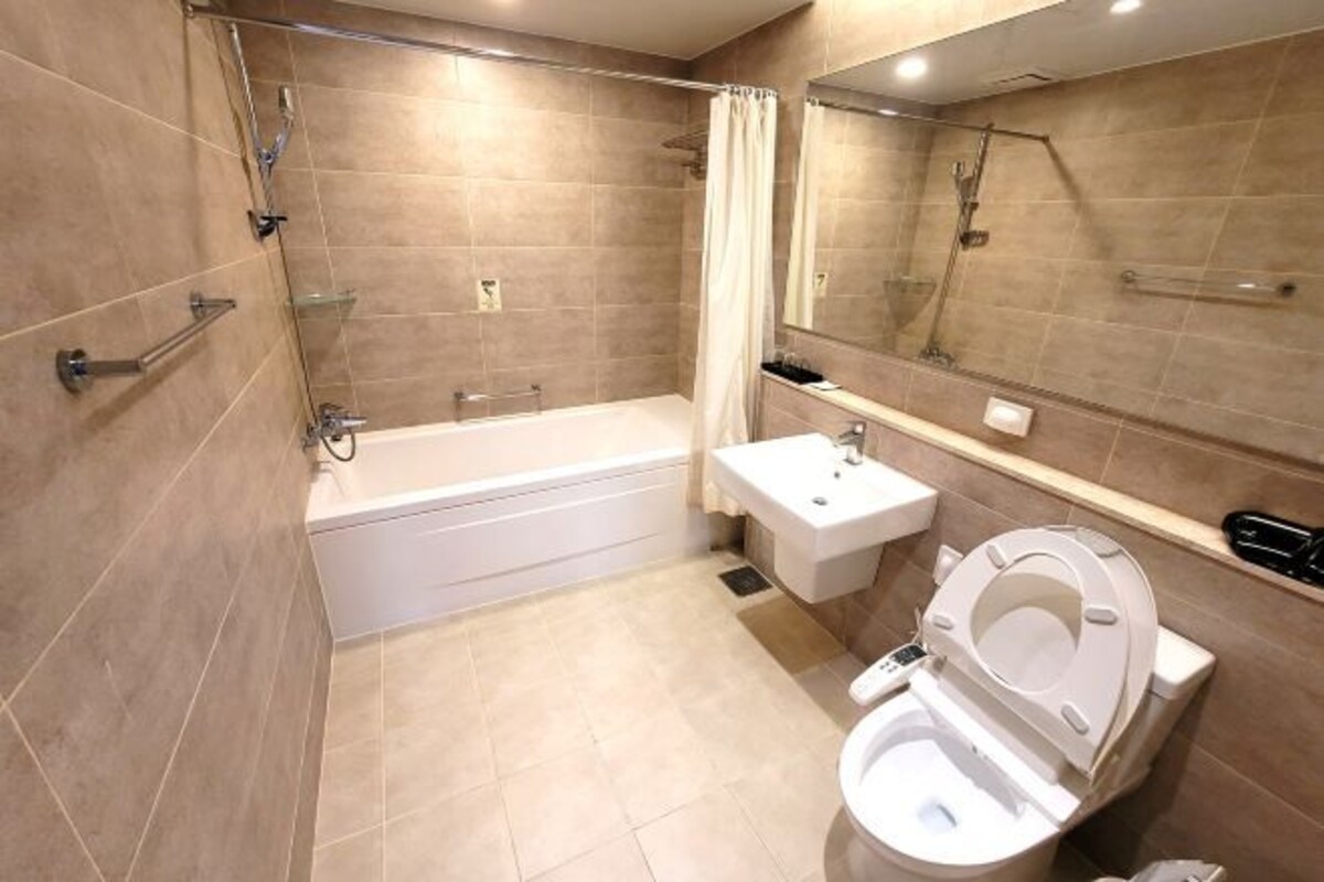 A modern bathroom with a bathtub, a toilet, a sink, and a shower.