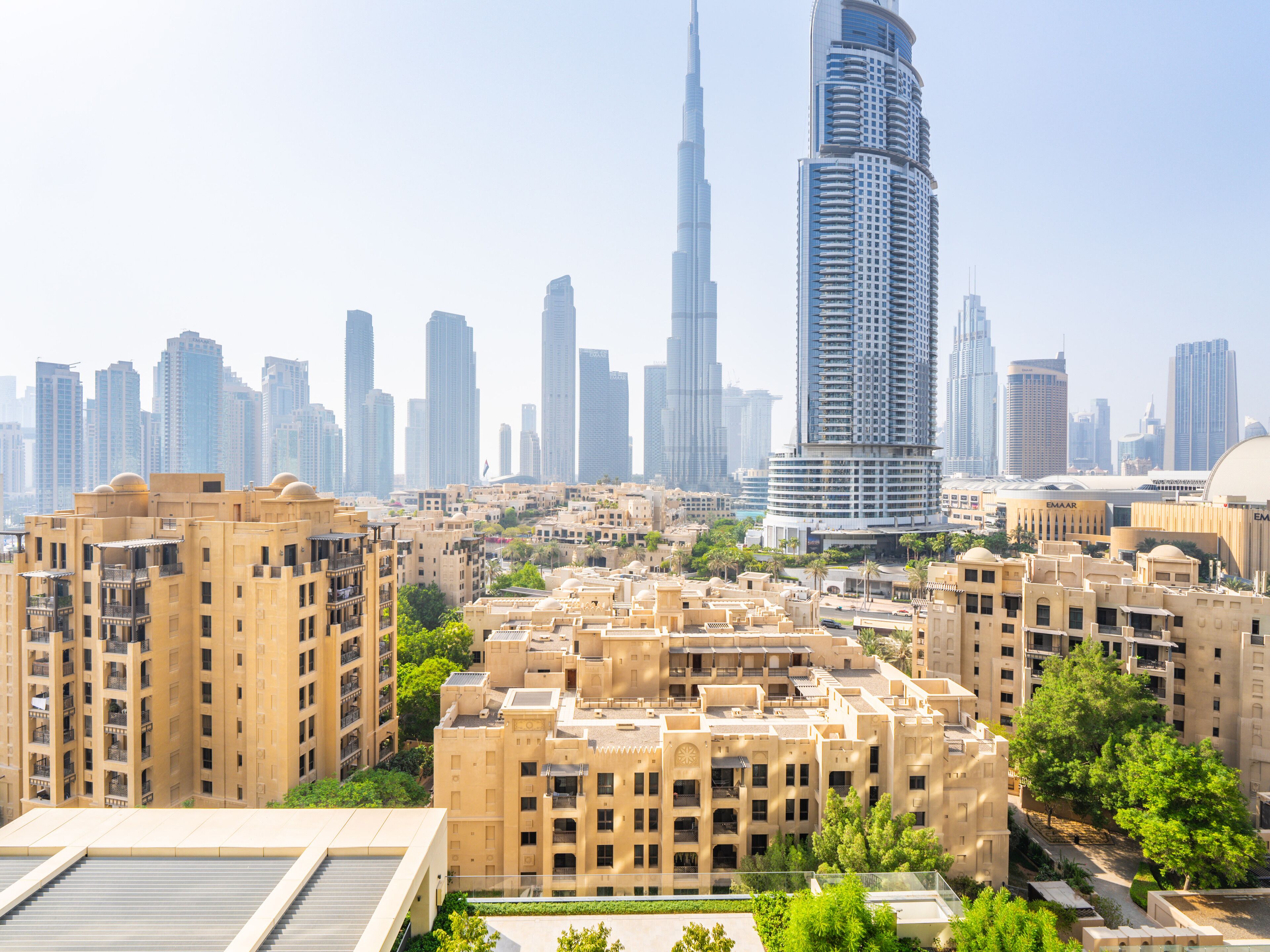 A cityscape with modern high-rise buildings and a prominent skyscraper in the background.
