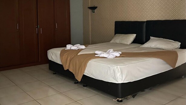 Ett hotellrum med en stor säng, en garderob och en vägg med ett mönster.