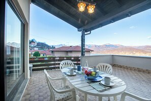 A balcony with a table set for two, a bowl of fruit, and a bottle of water. - Lake Maggiore View Terrace Over The Borromean Islands (Stresa)