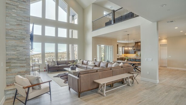 A spacious living area with a large sectional sofa, a bench, and a stone accent wall. - Spacious Utah Escape w/ Balcony & Mountain Views! (Brian Head)