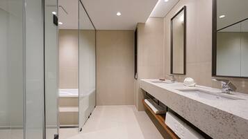A modern bathroom with a glass shower enclosure, a double sink vanity, and a large mirror.