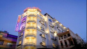 Um hotel de vários andares com um letreiro de neon chamativo na esquina.