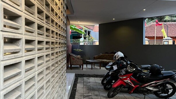 Un intérieur moderne avec une moto garée près d’un mur orné d’un motif en réseau.