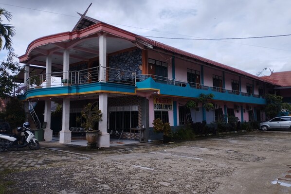 A multi-story building with a covered entrance and a balcony.
