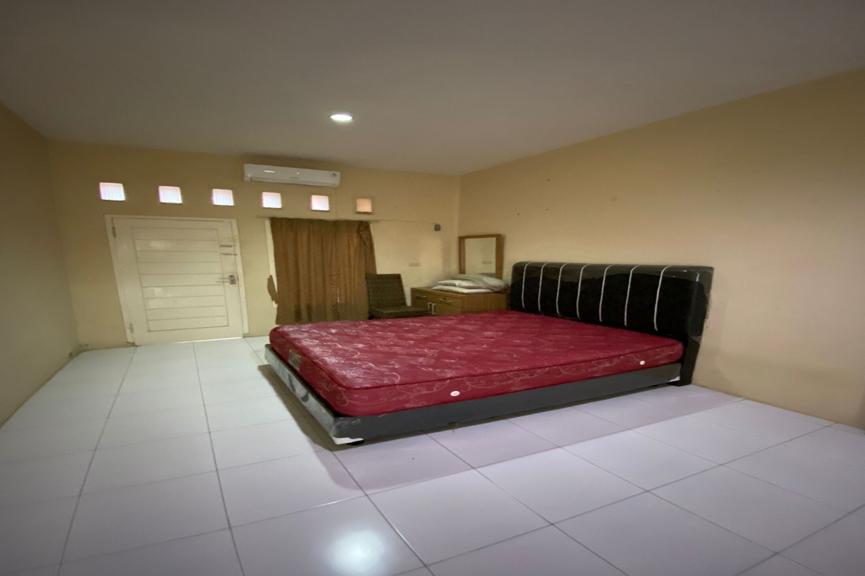 Un dormitorio con una cama grande, un armario, un escritorio y un espejo.