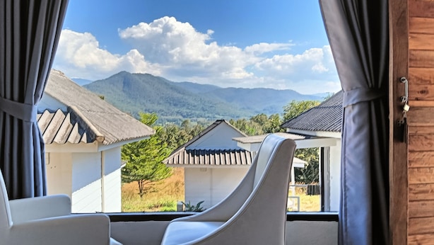 Une chambre avec vue sur les montagnes et les maisons traditionnelles.